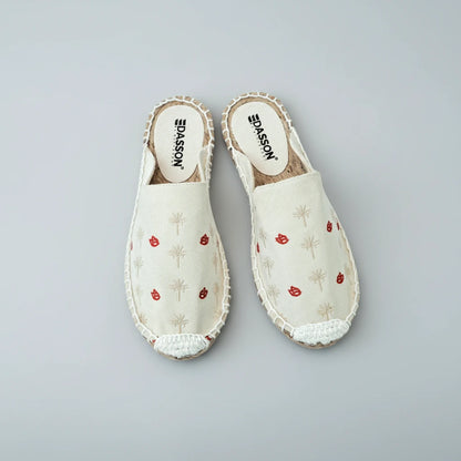 Pair of white slippers with red floral patterns on a white background