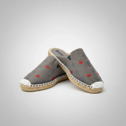 Gray slip-on shoe with floral embroidery on a white background