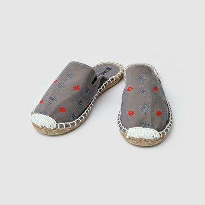 Pair of gray espadrilles with red floral embroidery on a white background
