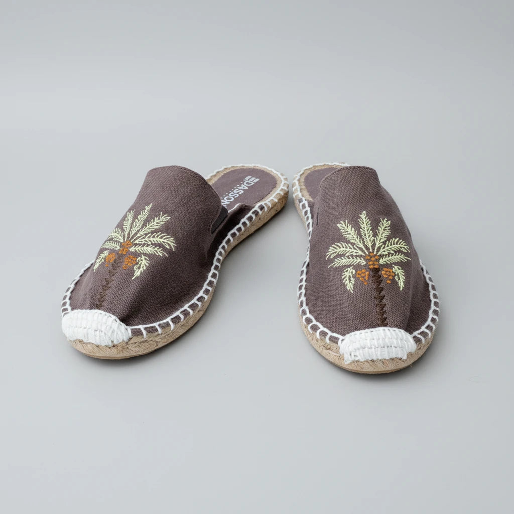 Pair of espadrilles with palm tree design on a white background