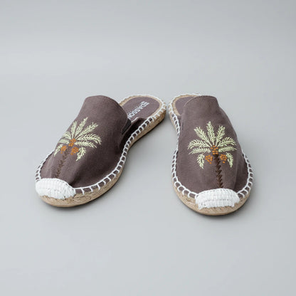 Pair of espadrilles with palm tree design on a white background