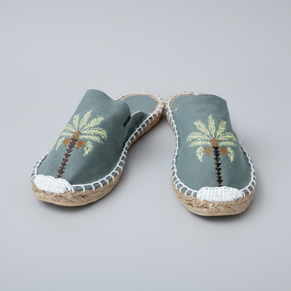 Pair of espadrilles with palm tree design on a white background