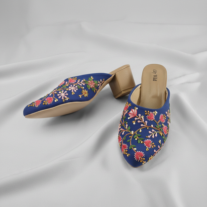 Pair of blue floral embroidered shoes on a white background