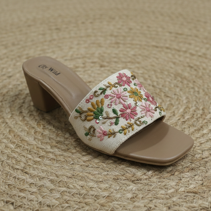 Embroidered sandal with floral design on a woven mat