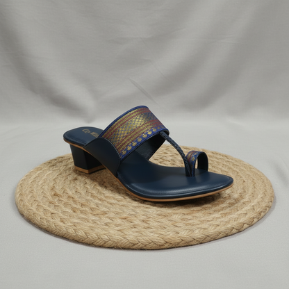 Navy sandal with decorative strap on a woven mat
