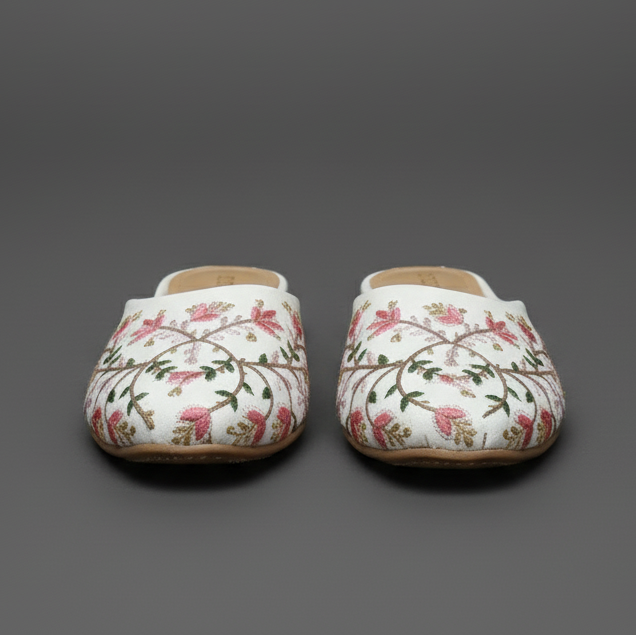 Floral-patterned shoes worn on a cobblestone street with a blurred background