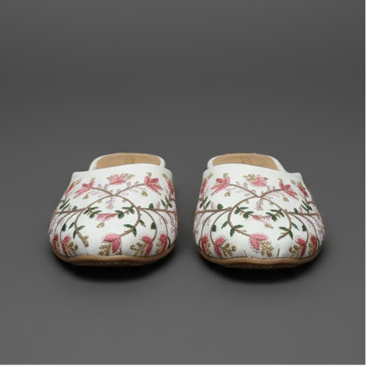 Floral-patterned shoes worn on a cobblestone street with a blurred background