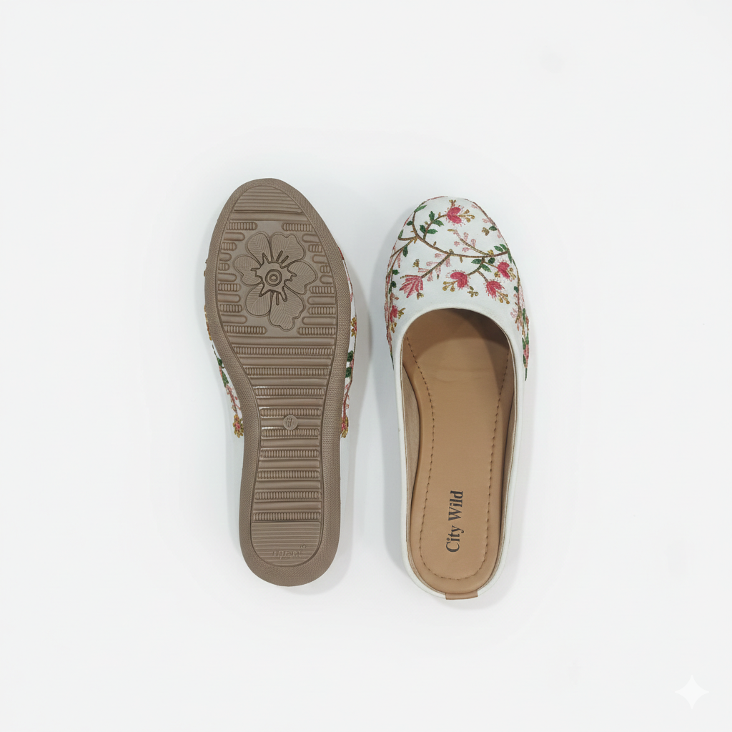 Floral flat shoe with sole showing brand name on a white background