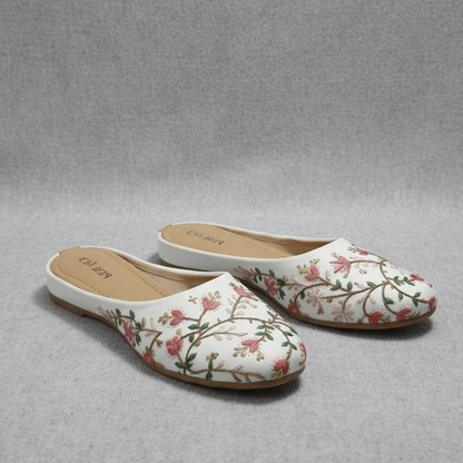 Floral slippers on a wooden table with a blurred cafe background