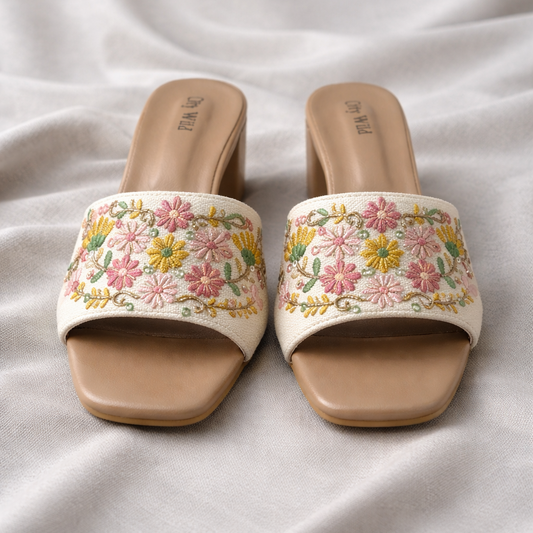 Pair of floral embroidered sandals on a light fabric background
