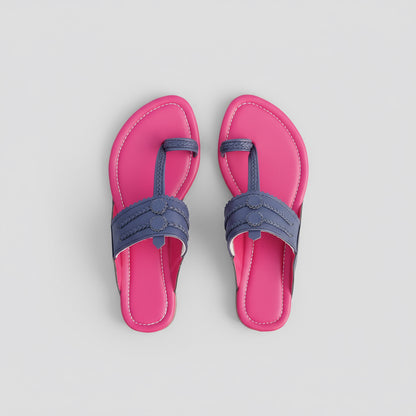 Pair of pink sandals with blue straps on a rocky surface
