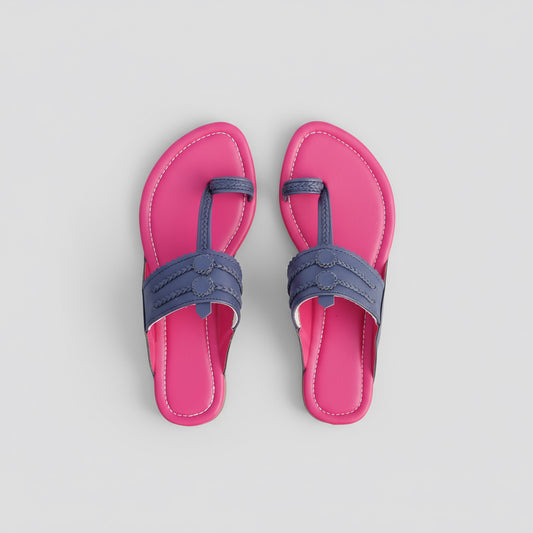 Pair of pink sandals with blue straps on a rocky surface