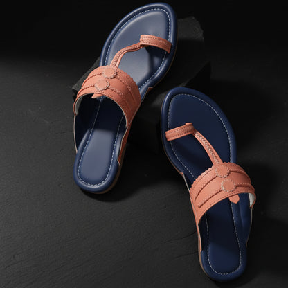 Blue sandals with pink straps on a rocky surface