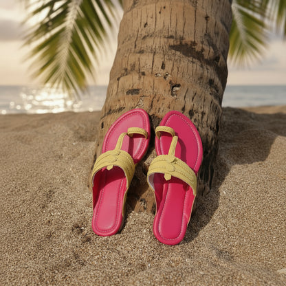 Pink sandals with yellow straps on a wooden log on a sandy background