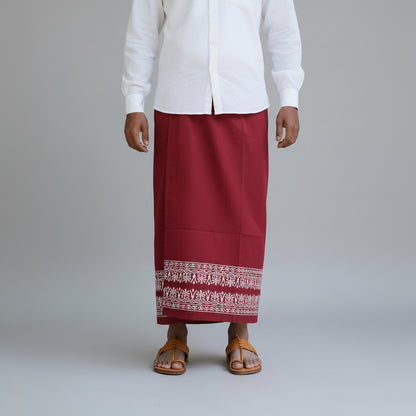 Person wearing a white shirt and red skirt with a patterned hem on a gray background