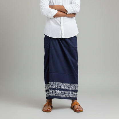 Person wearing a white shirt and navy skirt with elephant patterns on a plain background