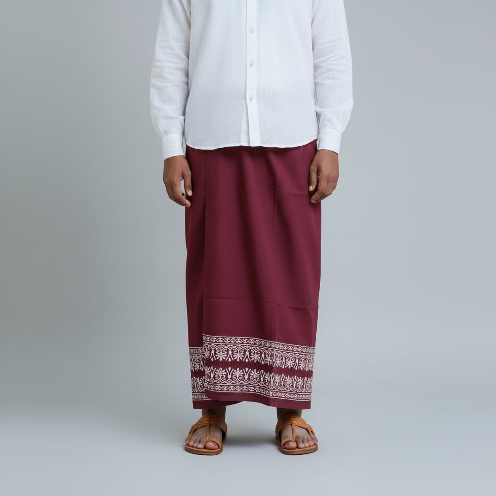 Person wearing a white shirt and maroon skirt with elephant pattern on a gray background