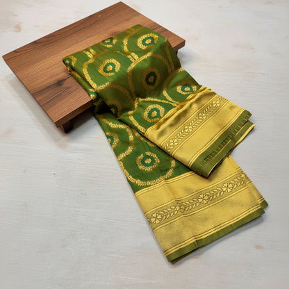 Green and gold saree with intricate patterns on a wooden and white background