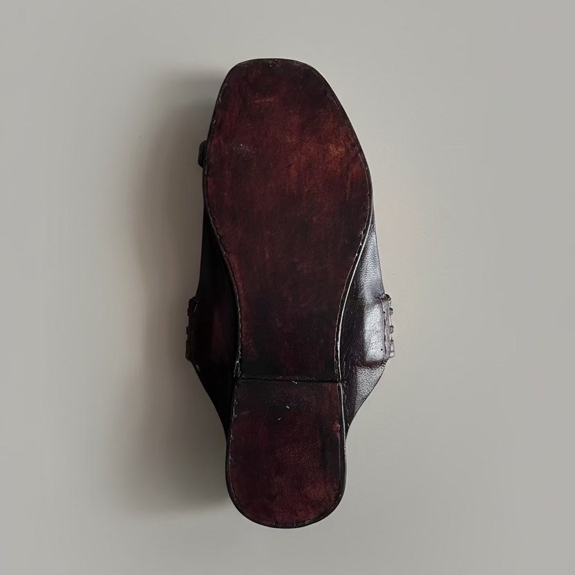 Brown leather shoe sole on a light gray floor