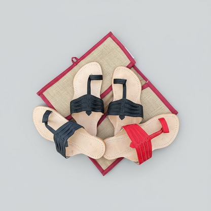 Pair of decorative kolhapuris with colourful straps on a grassy background
