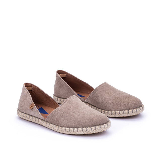 Pair of beige espadrilles on a white background