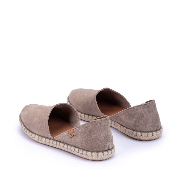 Pair of beige espadrilles on a white background