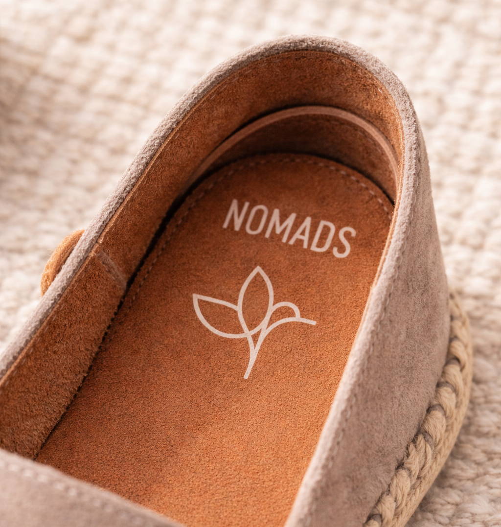 Close-up of a shoe with 'Nomads' branding on a textured background