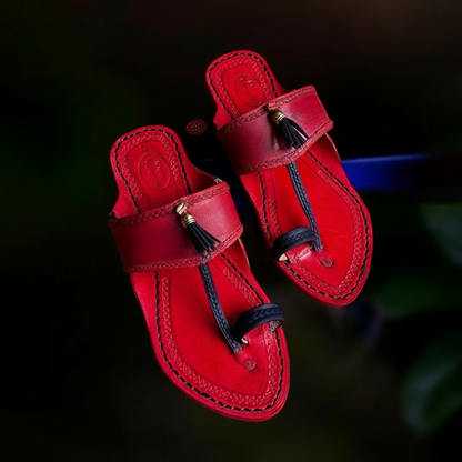 Red sandals with tassels on a dark background