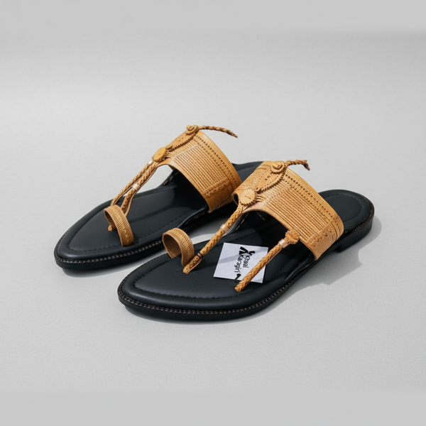 Black sandals with tan straps on a yellow background