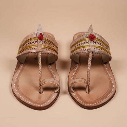 Pair of decorative sandals with floral accents on a beige background