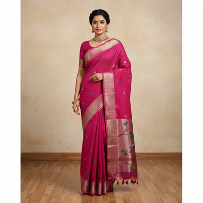 Pink saree with bird and floral patterns, held by a person, with flowers in the background.