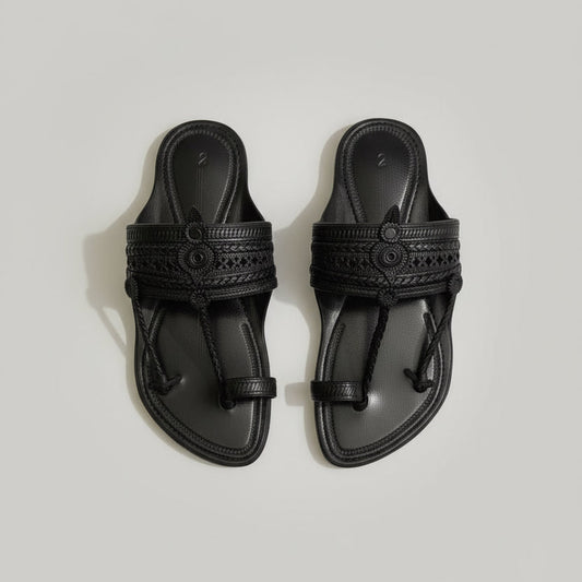 Pair of black sandals on a light gray marble surface