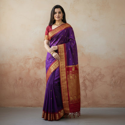 Woman wearing a purple and red saree with gold patterns, displayed on a wooden surface.
