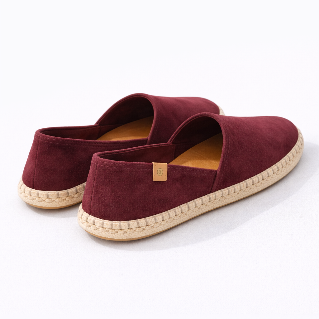 Pair of burgundy espadrilles on a white background