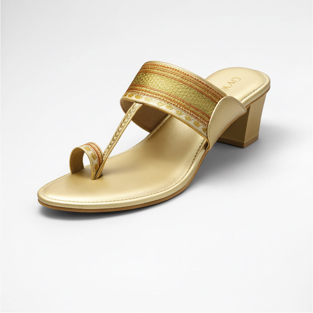 Gold sandal with a decorative strap on a white background