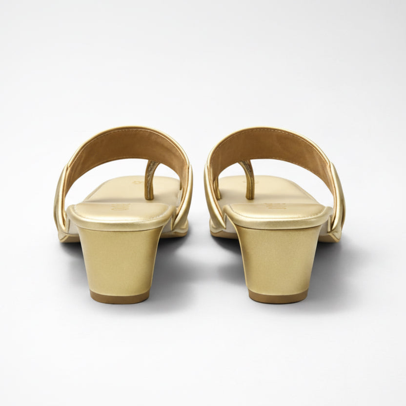 Pair of gold sandals on a white background