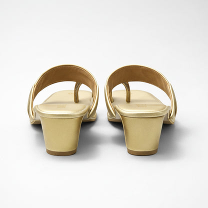 Pair of gold sandals on a white background