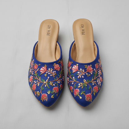 Pair of blue embroidered slippers on a white background