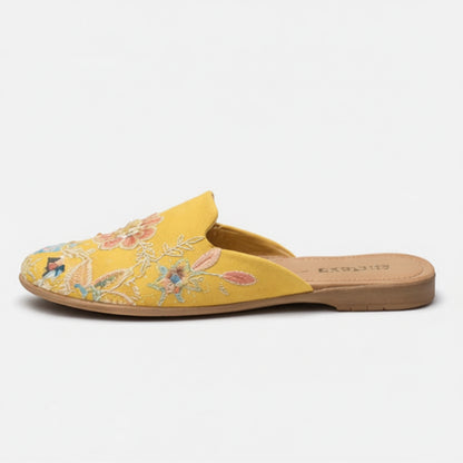 Yellow slipper with floral embroidery on a white background