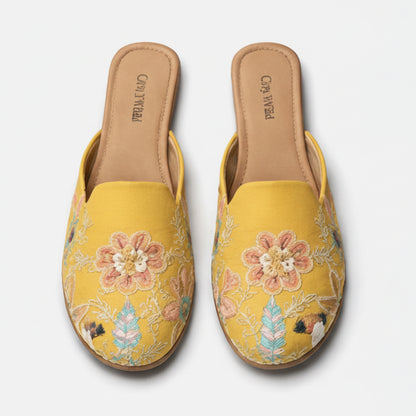 Pair of yellow embroidered slippers on a white background