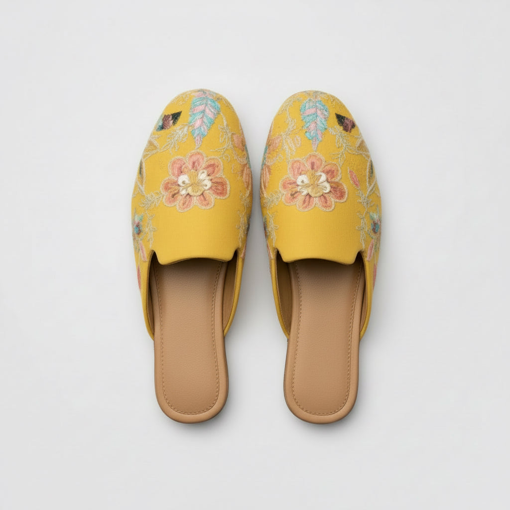 Yellow embroidered slippers on a white background