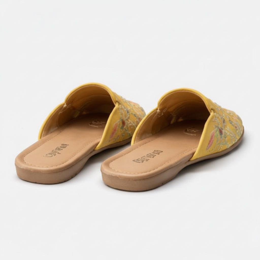 Pair of yellow sandals with floral pattern on a light gray background