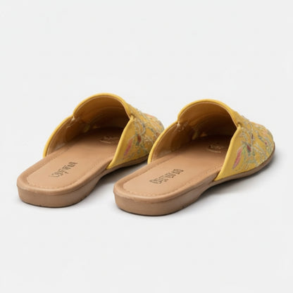 Pair of yellow sandals with floral pattern on a light gray background