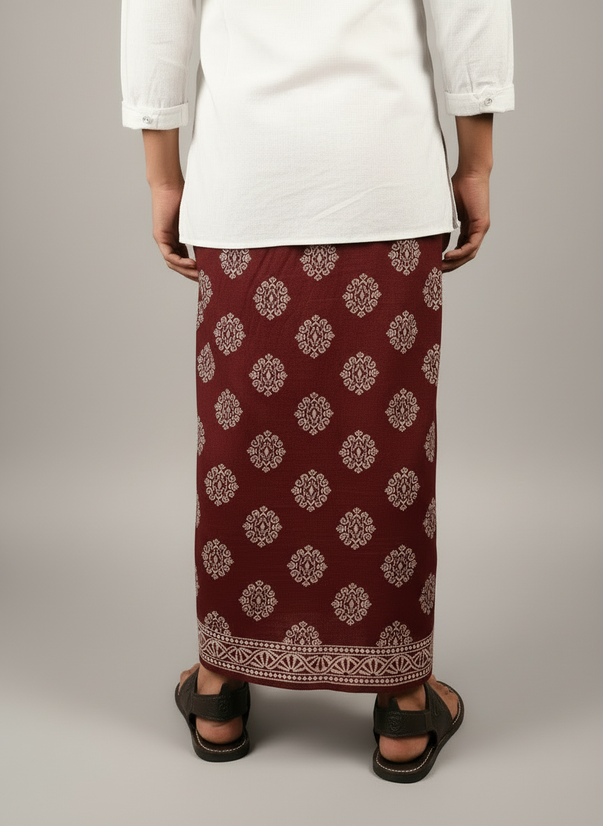 Person wearing a maroon patterned skirt with a plain white top on a light gray background